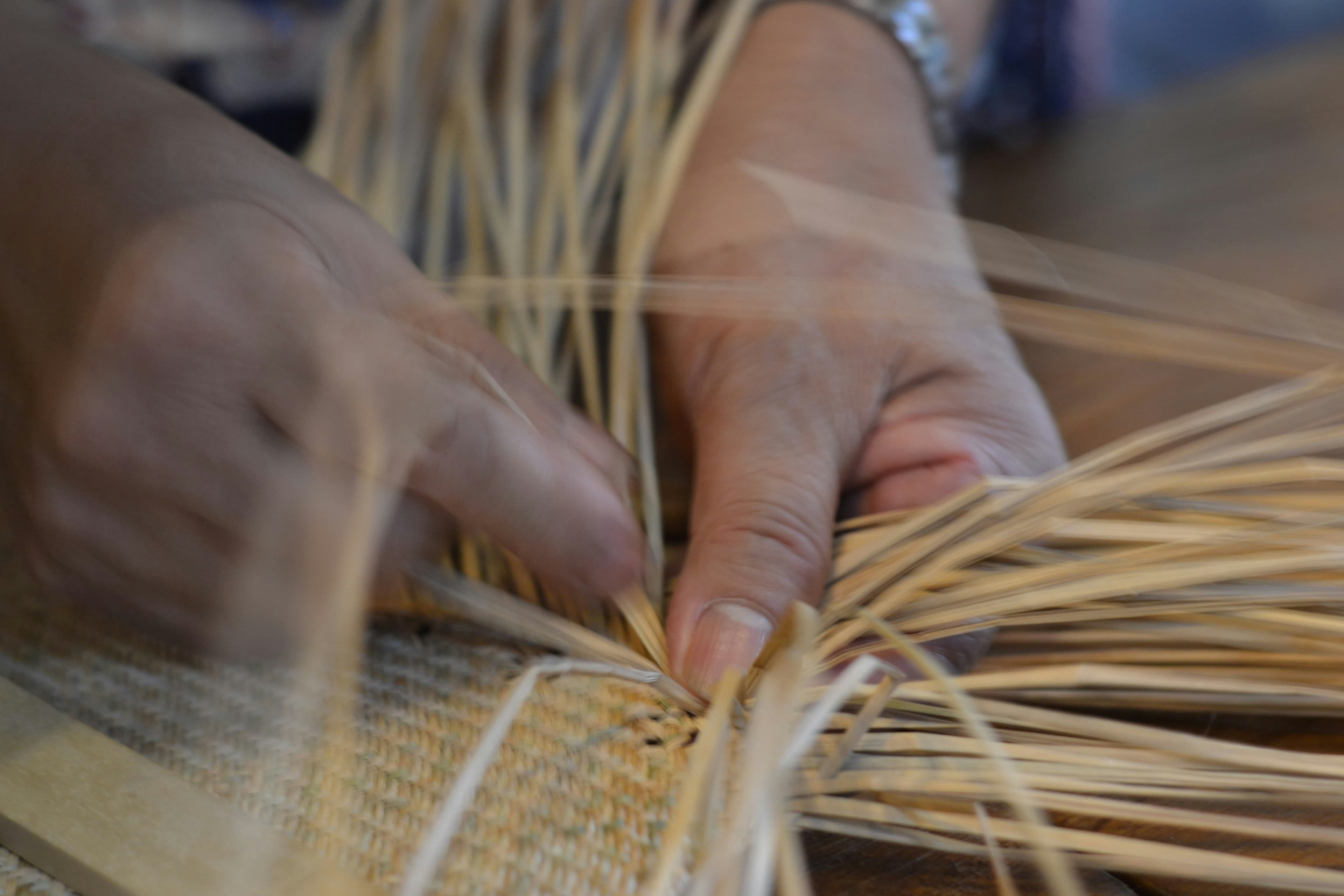 A maker's hands sorting freshly harvested produce into woven baskets
